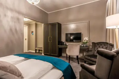 a hotel room with a bed and a desk and a television at Home Hotel Grand Gjøvik in Gjøvik