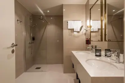 a bathroom with a sink and a shower at Home Hotel Grand Gjøvik in Gjøvik