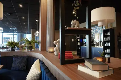 a living room with a blue couch and a mirror at Home Hotel Grand Olav in Trondheim