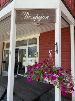 a sign for a restaurant with flowers on a porch at Trædal Hotel in Sunndalsøra