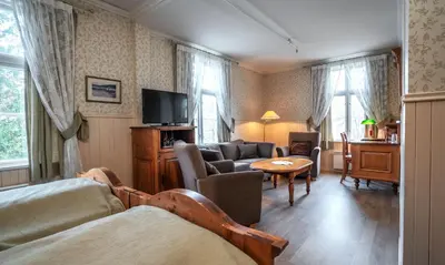 a living room with a couch and a table at Thon Hotel Selbusjøen in Selbu