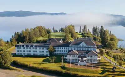an aerial view of a large white building on a hill at Thon Hotel Selbusjøen in Selbu