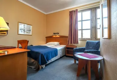 a hotel room with a bed and a chair at Thon Hotel Selbusjøen in Selbu