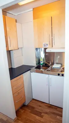 a small kitchen with white cabinets and a sink at Sandmoen Bed & Breakfast, Free Parking in Trondheim