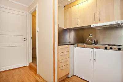 a kitchen with white cabinets and a sink at Sandmoen Bed & Breakfast, Free Parking in Trondheim