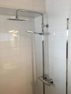 a shower stall in a bathroom with white tiles at Sandmoen Bed & Breakfast, Free Parking in Trondheim
