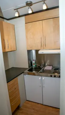 a small kitchen with white cabinets and a sink at Sandmoen Bed & Breakfast, Free Parking in Trondheim