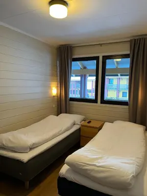two beds in a room with two windows at Sandmoen Bed & Breakfast, Free Parking in Trondheim