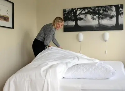 a woman standing on top of a bed at Sandmoen Bed & Breakfast, Free Parking in Trondheim