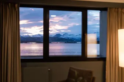 a window with a view of the water and mountains at Scandic Alexandra Molde in Molde