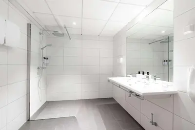 a white bathroom with a sink and a shower at Scandic Alexandra Molde in Molde