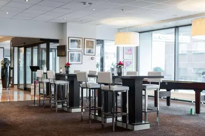 a lobby with a bar with stools and a pool table at Scandic Alexandra Molde in Molde