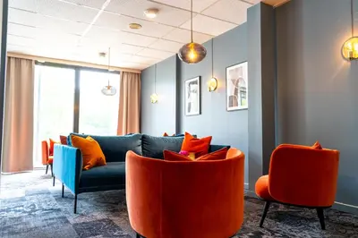 a living room with a blue couch and orange chairs at Thon Hotel Otta in Otta