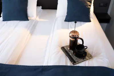 a tea kettle on a tray on a bed at Thon Hotel Backlund in Levanger