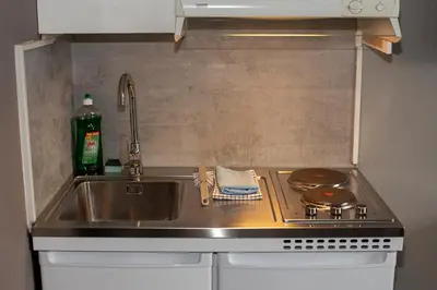 a kitchen counter with a sink and a stove at Pensjonat Jarlen in Trondheim