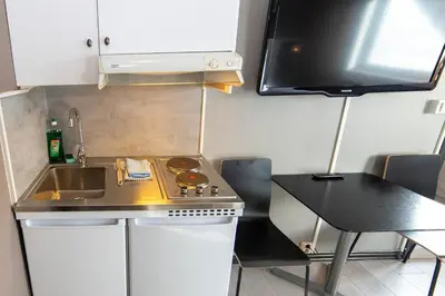 a small kitchen with a stove and a sink at Pensjonat Jarlen in Trondheim