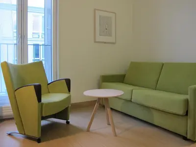 a living room with a couch and a table and chairs at Hotel St. Olav in Trondheim