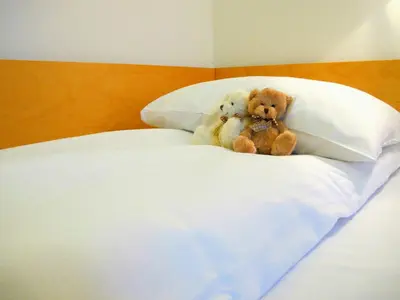 two teddy bears sitting on top of a bed at Hotel St. Olav in Trondheim