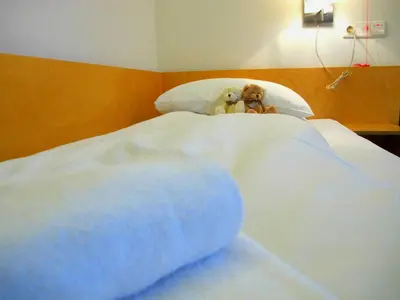 two teddy bears sitting on top of a bed at Hotel St. Olav in Trondheim