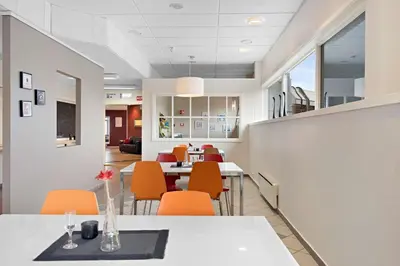 a dining room with orange chairs and tables at Stav Hotel in Malvik