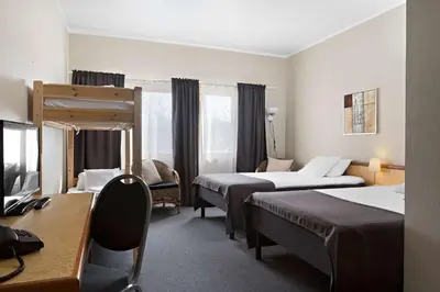 a hotel room with two beds and a desk at Stav Hotel in Malvik