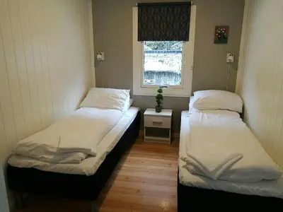 two beds in a room with a window at Steinshølen Holiday Home in Flåm