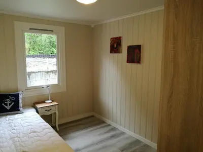a bedroom with a bed and a window at Steinshølen Holiday Home in Flåm