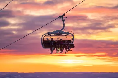 a group of people riding a ski lift at sunset at Trysil Hotel in Trysil