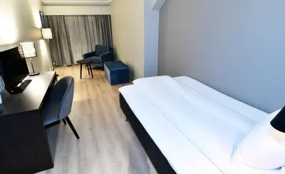 a hotel room with a large bed and a desk at Thon Hotel Baronen in Ålesund
