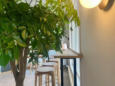 a row of stools next to a table with a tree at Comfort Hotel Park in Trondheim