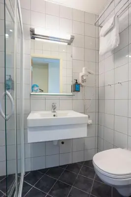 a white bathroom with a sink and a toilet at Comfort Hotel Park in Trondheim