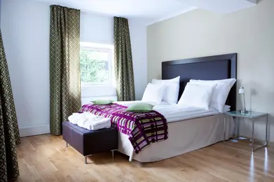 a bedroom with a large bed and a window at Quality Hotel Augustin in Trondheim