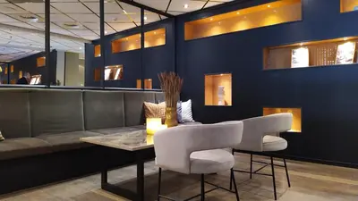a restaurant with a couch and a table and chairs at Quality Hotel Augustin in Trondheim