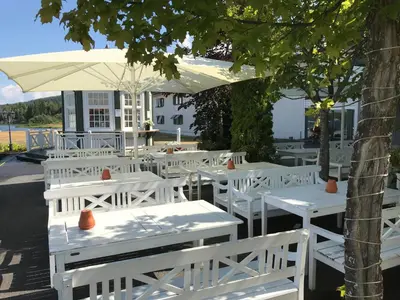 a white table and chairs under a white umbrella at Tyrifjord Hotell in Vikersund