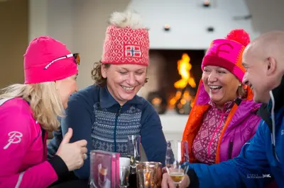 a group of women sitting at a table wearing pink hats at Ustedalen Hotel Geilo in Geilo