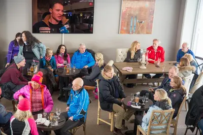 a group of people sitting at tables in a restaurant at Ustedalen Hotel Geilo in Geilo