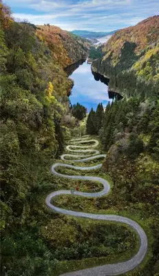 a winding road on a hill with a river at Fjordslottet Hotel in Fotlandsvåg