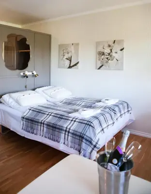 a bedroom with a bed and a table with a table sidx sidx at Fjordslottet Hotel in Fotlandsvåg