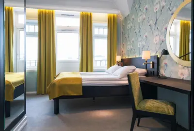 a bedroom with a bed and a desk and a mirror at Thon Hotel Nidaros in Trondheim