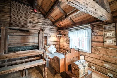 a bedroom in a log cabin with a bed and a window at Håholmen - by Classic Norway Hotels in Karvåg