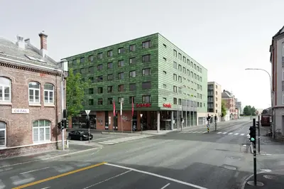 an empty city street with a green building at Scandic Solsiden in Trondheim