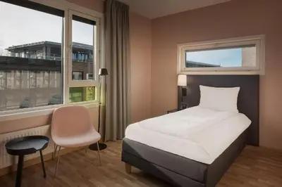 a hotel room with a bed and a window at Scandic Solsiden in Trondheim