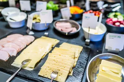 a table with cheese and meats and other foods at Scandic Solsiden in Trondheim