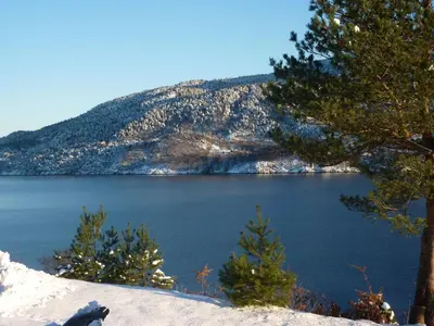a view of a lake with trees and a mountain at Langenuen Motel & Camping in Stord