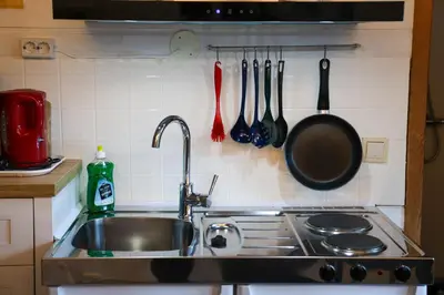 a kitchen with a sink and a stove with utensils at Langenuen Motel & Camping in Stord