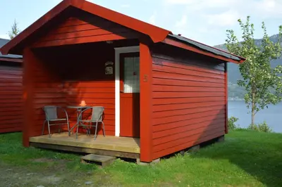 a red shed with a table and chairs in it at Langenuen Motel & Camping in Stord