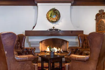 a living room with leather chairs and a fireplace at Dr. Holms Hotel in Geilo