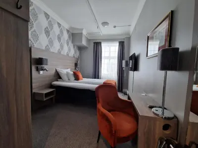 a hotel room with a bed and a desk and a chair at Dr. Holms Hotel in Geilo