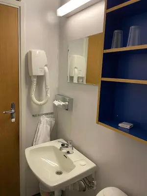 a bathroom with a sink and a phone on the wall at Dovre Motell in Dovre