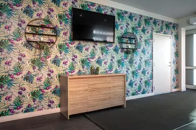 a living room with a tv on a floral wall at Thon Hotel Storgata in Kristiansund